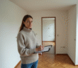 Femme vérifiant un appartement vide avec un clipboard