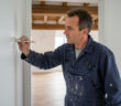 Peintre homme en overalls peignant un mur blanc à Rennes